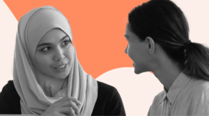 Two colleagues engaged in a thoughtful conversation, with one woman wearing a hijab, set against a vibrant orange and white background, showcasing diversity and meaningful dialogue in the workplace.