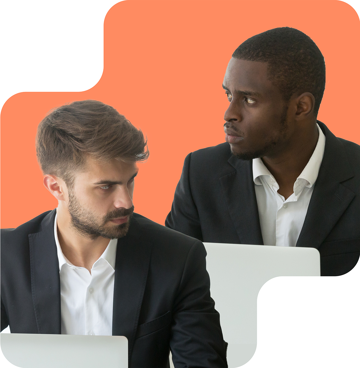 Image shows two men in business attire, sitting and looking intently at each other. Both appear serious and focused. The background features a contrasting orange and beige color scheme. The image suggests a moment of intense discussion or negotiation, reflecting a professional and possibly competitive interaction.