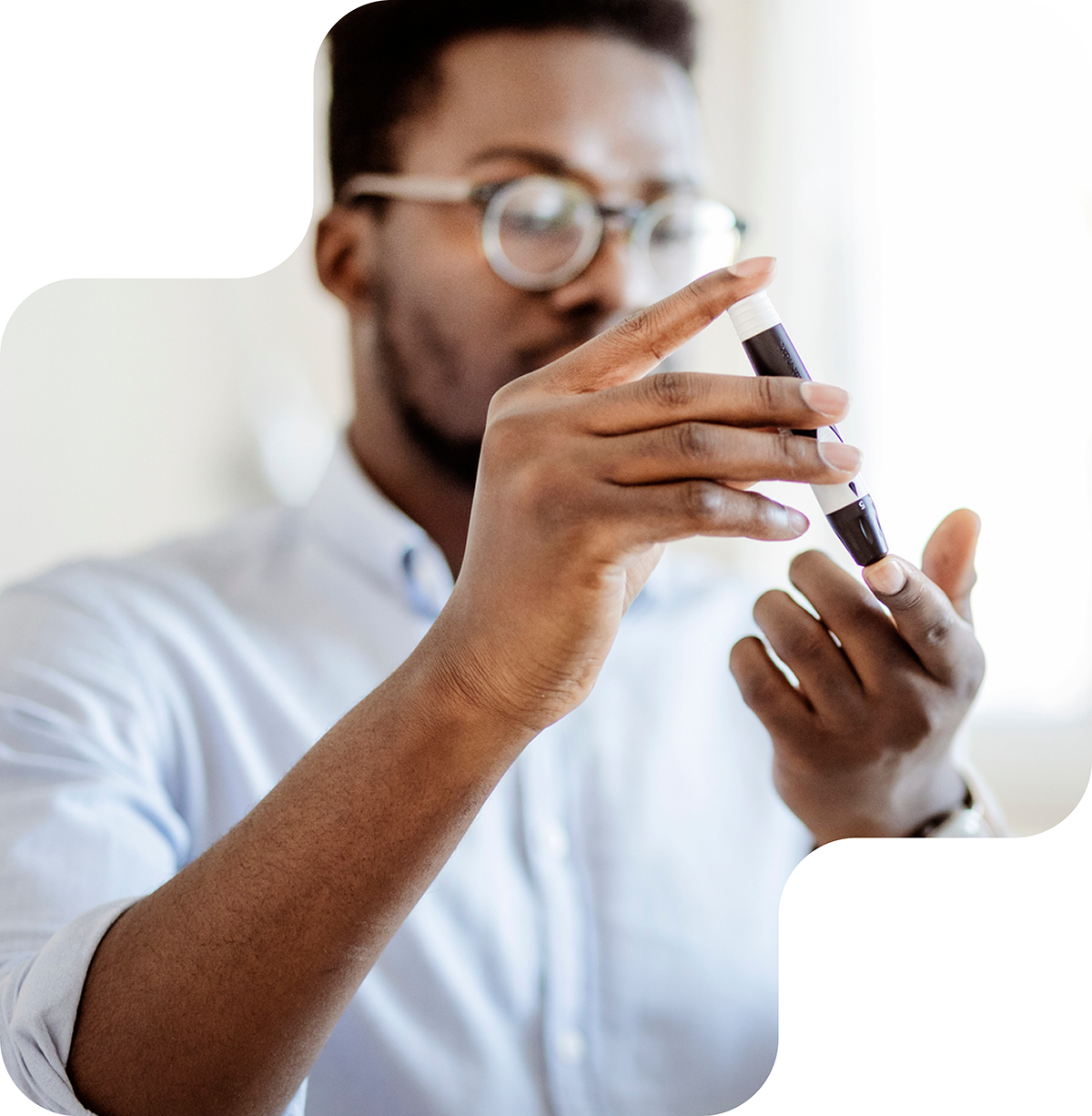 Image shows a man with glasses carefully handling a syringe. He appears focused as he prepares the injection. The image conveys a sense of precision, care, and professionalism, likely in a medical or scientific context.