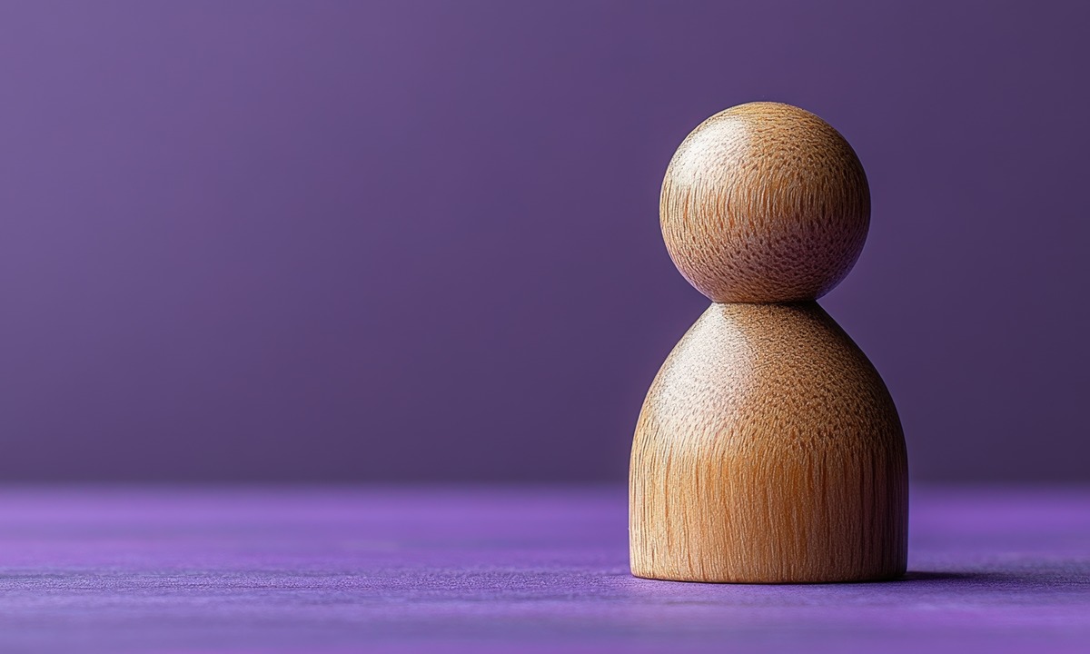 Wooden figure on a purple background representing inclusion and diversity, featured for a blog on Diversio's role in helping Swedish organisations comply and thrive.