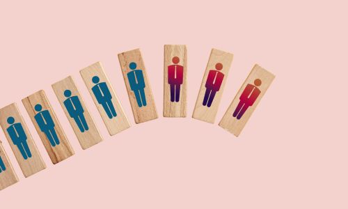 Wooden blocks with person icons, transitioning from blue to red, representing the employee experience maturity model.