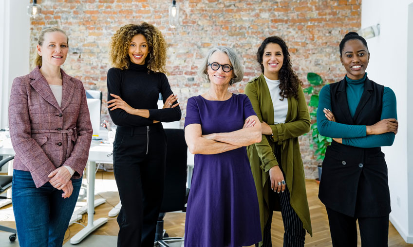 Five diverse women executives in investment industry office demonstrating inclusive culture and gender equity in finance