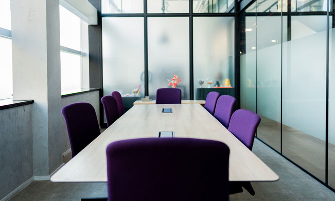 Modern conference room with purple chairs and glass walls representing systematic culture infrastructure and transparent decision-making processes