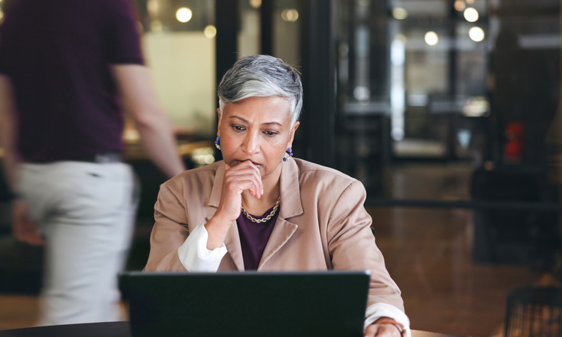 Professional woman reviewing disappointing culture initiative results on laptop, representing how good intentions can deliver poor outcomes in workplace transformation